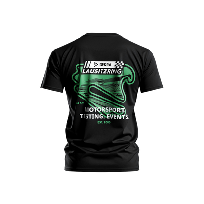 Schwarzes DEKRA Lausitzring T-Shirt mit großem grünen Rückenprint des Lausitzrings, Motorsport- und Event-Aufdruck sowie „EST. 2000“ – offizielles DEKRA Lausitzring Merchandise.