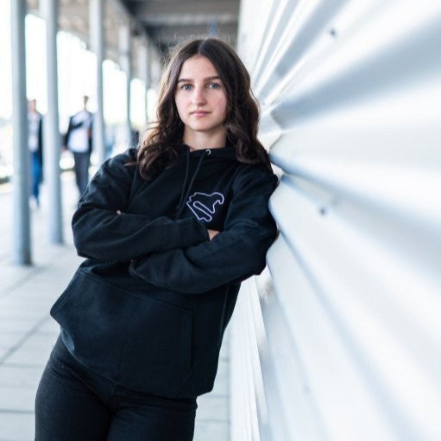 Person trägt den schwarzen Hoodie Motorsport, Testing & Events am DEKRA Lausitzring, sportlicher Kapuzenpullover mit Rennstrecken-Logo für Motorsportbegeisterte