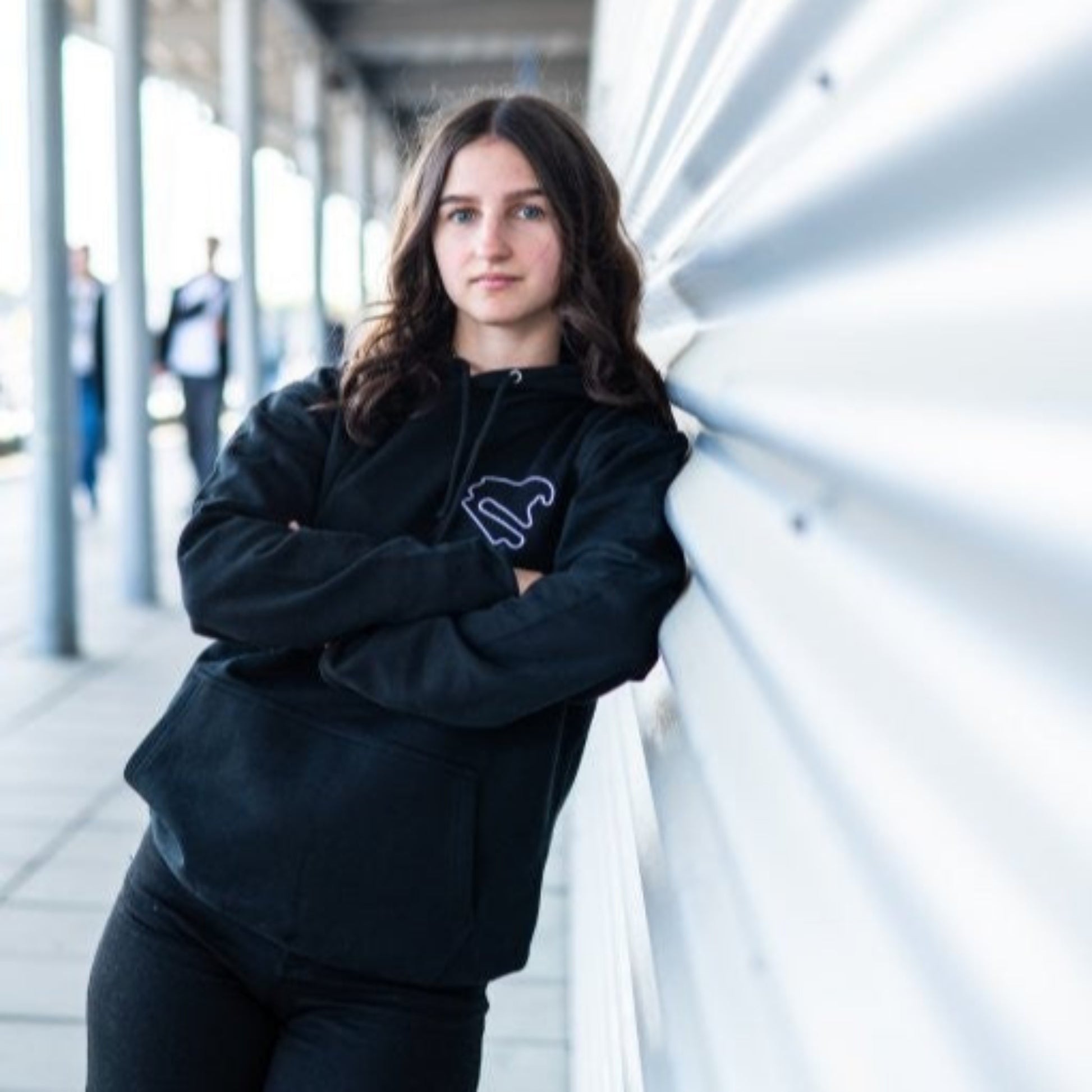 Person trägt den schwarzen Hoodie Motorsport, Testing & Events am DEKRA Lausitzring, sportlicher Kapuzenpullover mit Rennstrecken-Logo für Motorsportbegeisterte