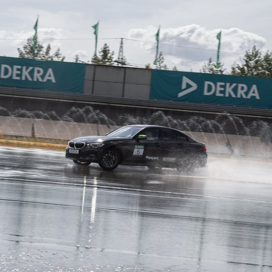 Schwarzer BMW beim PKW Perfektions-Training am DEKRA Lausitzring, präzises Fahrverhalten und Fahrzeugkontrolle auf nasser Strecke für erfahrene Fahrer
