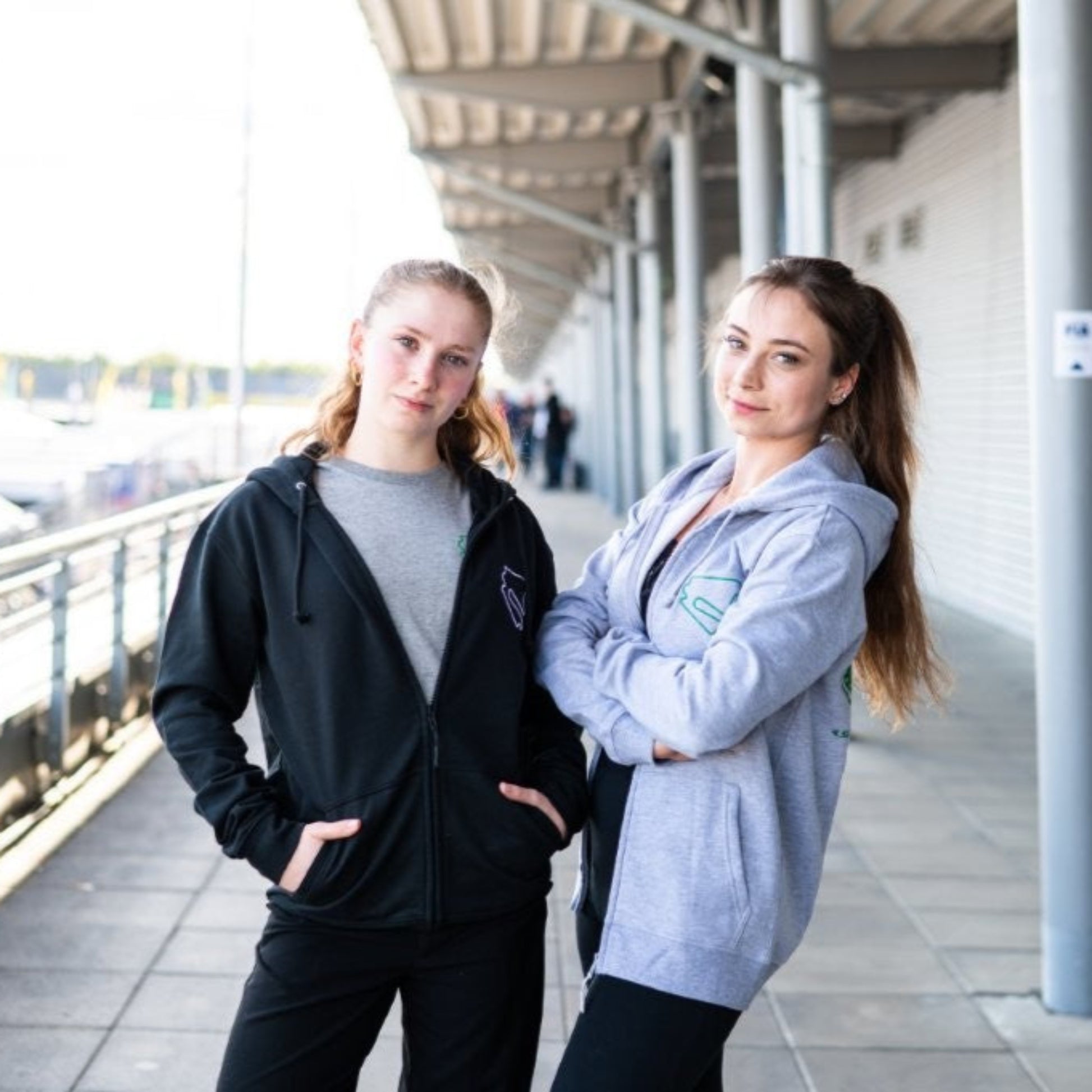 Zwei Personen tragen den Zip Hoodie Motorsport, Testing & Events am DEKRA Lausitzring, bequeme Teamwear mit sportlichem Design für Fans und Teilnehmer